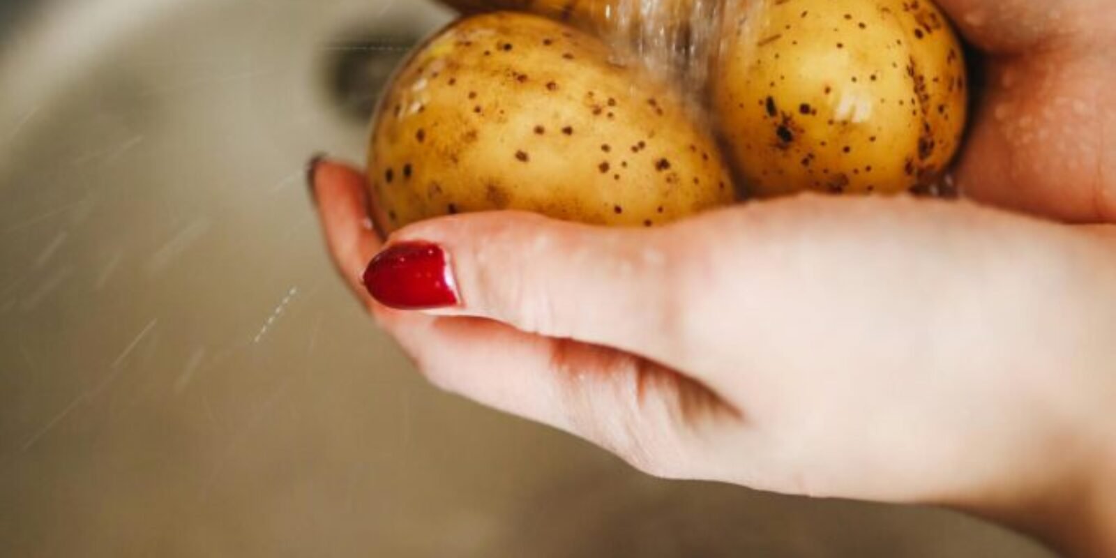 Frau wäscht Kartoffeln, die resistente Stärke enthalten