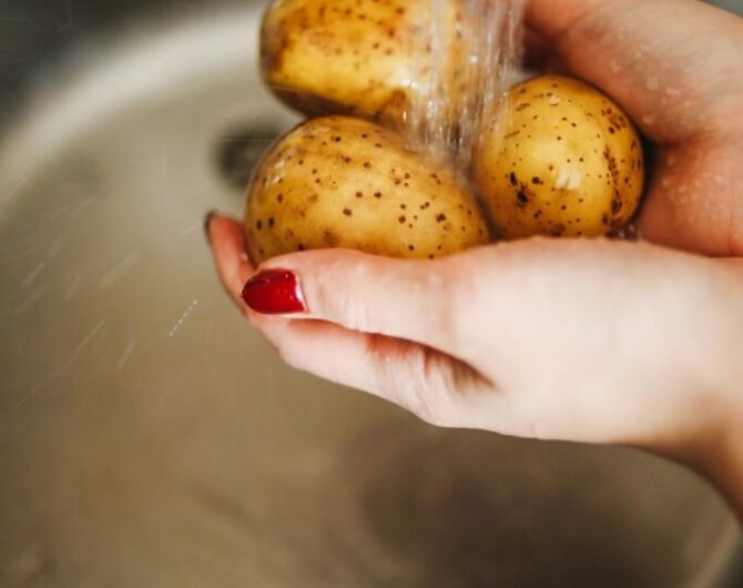 Frau wäscht Kartoffeln, die resistente Stärke enthalten